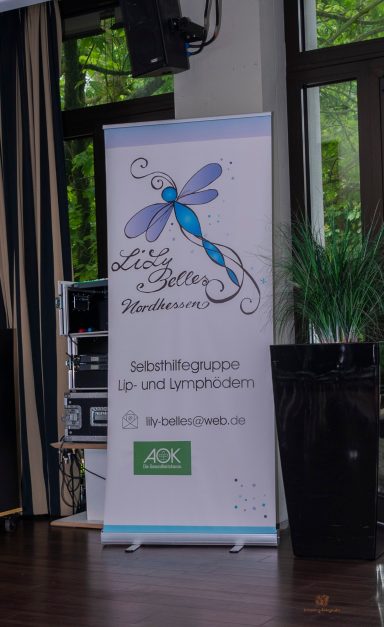 Rollup-Banner mit einer Libelle und dem Slogan "Lebensfreude pur" in einem Innenraum.